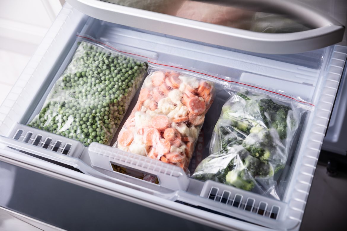 An Overhead View Of Frozen Vegetables In Plastic Bag Over Refrigerator Tray with an article of what not to freeze!